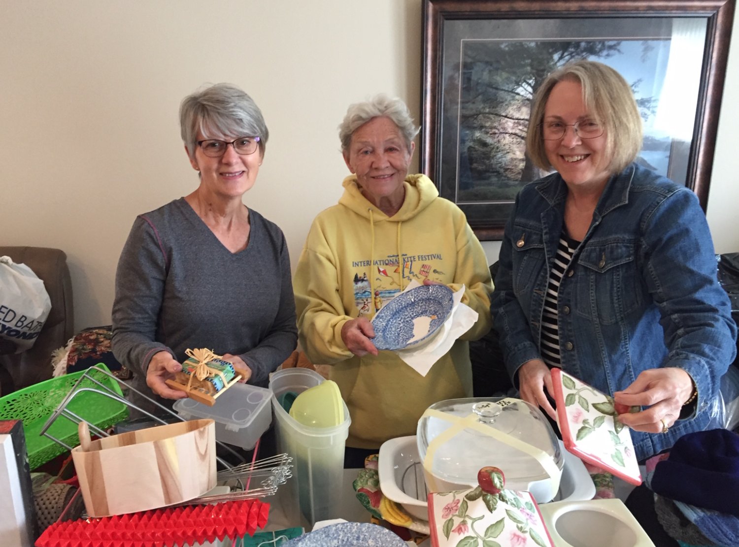Neighbors of Colleen Hoss help organize items for an upcoming yard sale. Hoss will donate profits from the fundraiser to the Alzheimer’s Association.